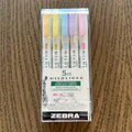 Pack of Zebra highlighters on a wooden surface