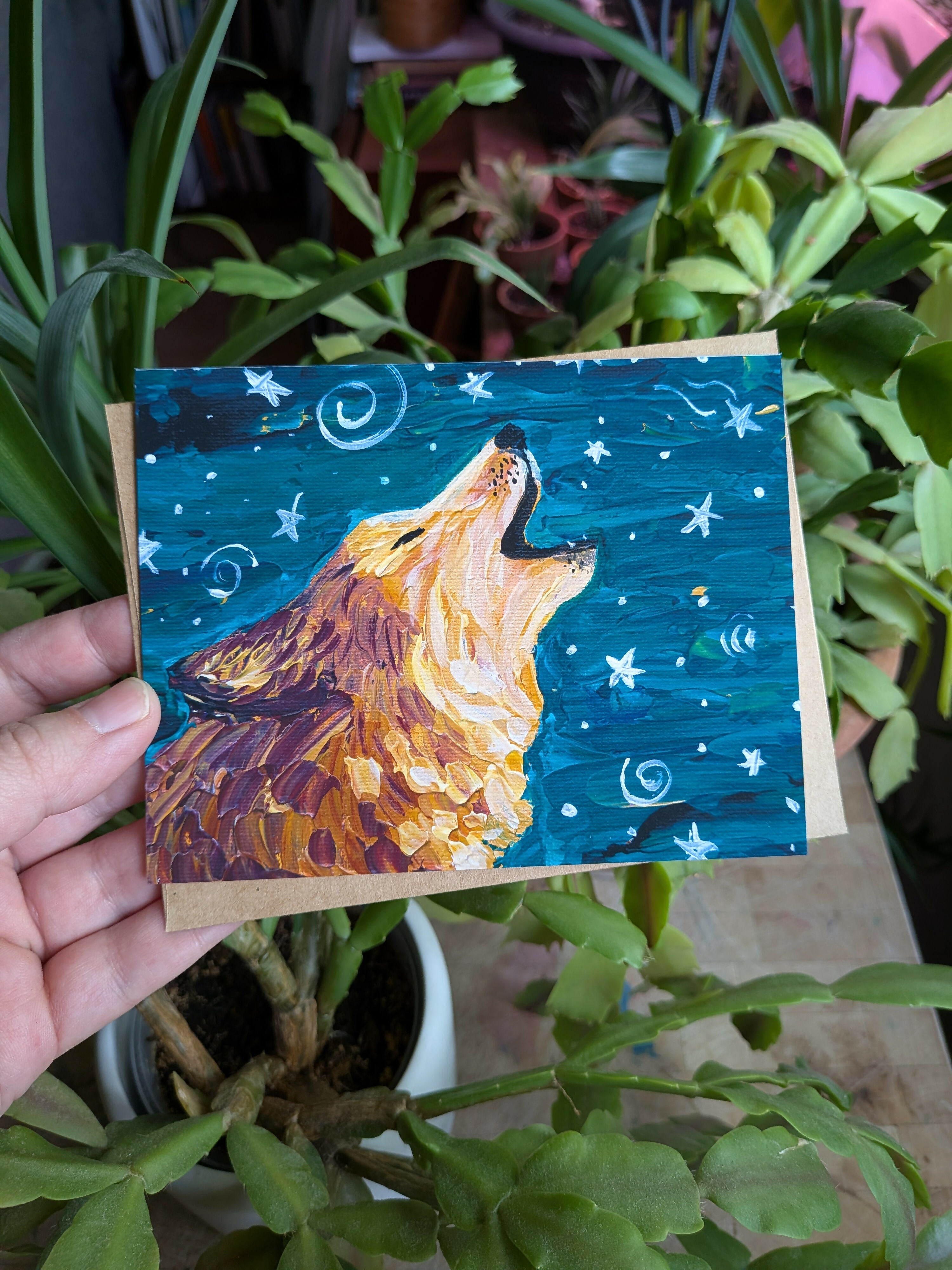 A printed greeting card with art of a wolf howling at a starry sky.